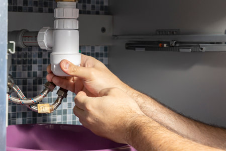 The plumber removes the blockage in the pipesの写真素材