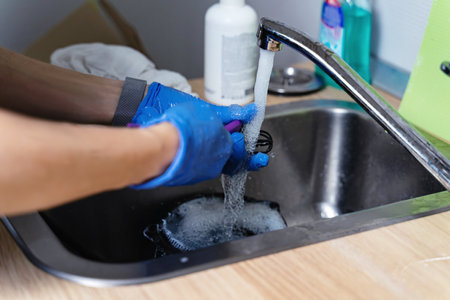 Beauty and hygiene industry. Master in medical gloves washes tools with waterの写真素材