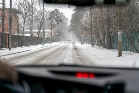 car drives on a winter road in a blizzard. inside view. the car in front went into a snow driftの写真素材