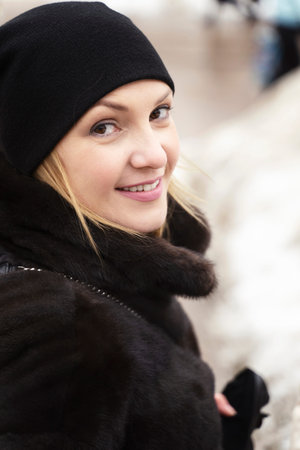 portrait of a smiling caucasian woman 30 years old in a fur coat and hat