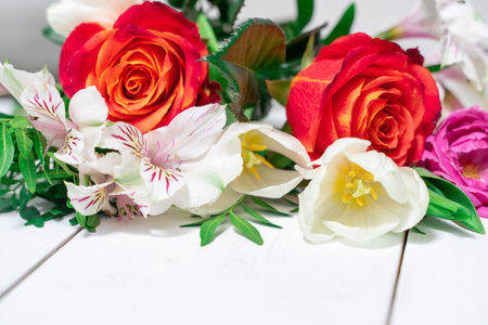 bouquet of spring flowers on a white wooden background with place for text. mock up with copy spaceの写真素材