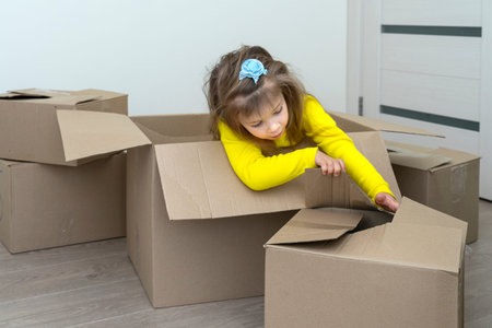 happy little girl in a cardboard box to move.の写真素材