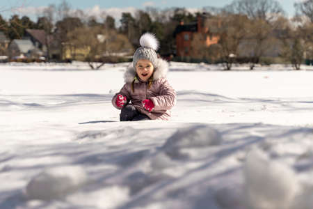 happy little girl playing in the snowの写真素材