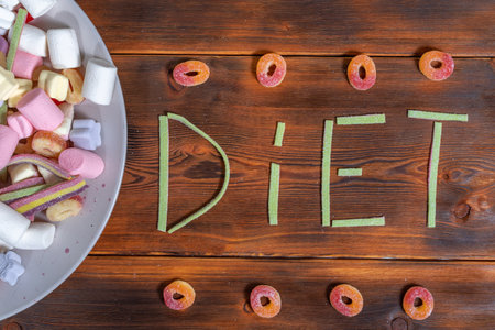 A large plate with sweets, the word diet is written with sweets. The concept of opponents of dieting and body positiveの写真素材