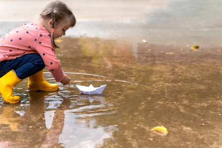 cute little girl playing with paper boatの写真素材
