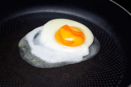 an egg in sunglasses and fried in a pan with a smileの写真素材