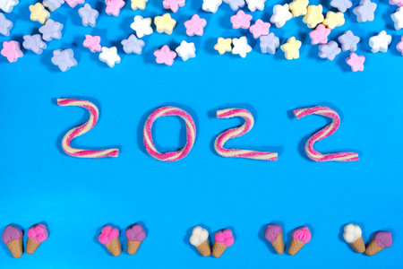 New Year 2022 made of gummies and marshmallows. Winter food background concept.