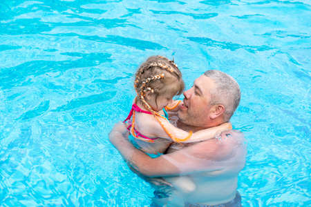 dad and little dod spend the weekend at the swimming poolの写真素材