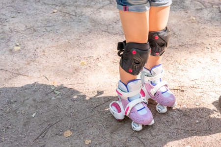 child on roller skates in protective sportswear. legs close upの写真素材