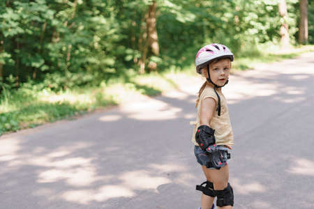 little girl learning to roller skate. baby in protective sportswearの写真素材