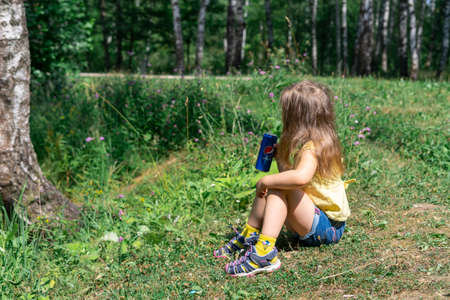 11/07/2021 Moscow, Russia A little girl in a yellow T-shirt drinks Pepsi Cola on a hot summer dayのeditorial素材