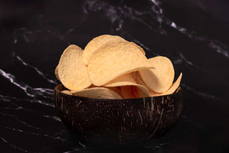 potato chips in a black plate, close-upの写真素材