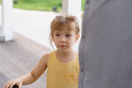 caucasian little girl in a yellow dress walking in the park