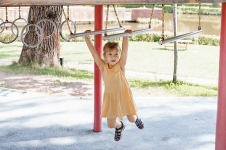 caucasian little girl playing on the playground on a summer day