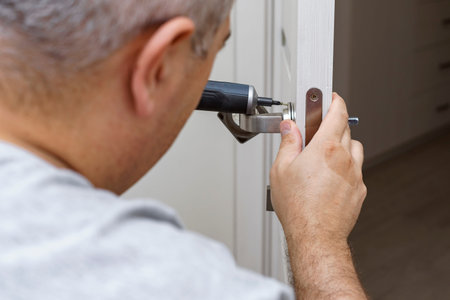 Locksmith repairing or installing a door lock in the house.の写真素材
