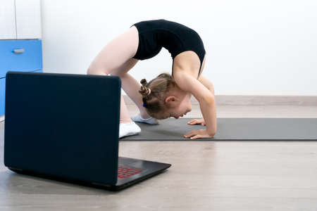 online rhythmic gymnastics. girl preschooler doing rhythmic gymnastics with a trainer onlineの写真素材