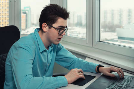 young employee looking at laptop screen and typingの写真素材