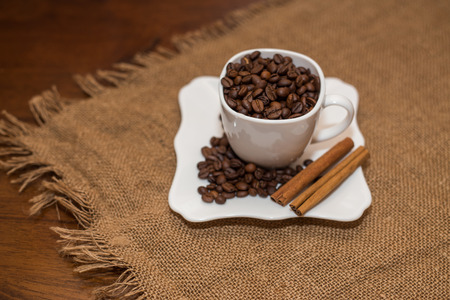 coffee beans and cinnamon white cup and saucer on a table brown texture units large lot of grainの写真素材