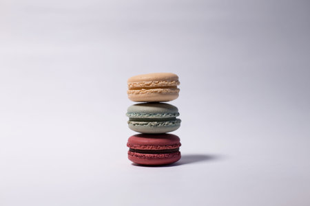 Yellow, blue and pink macarons on the white background lay on top of each others