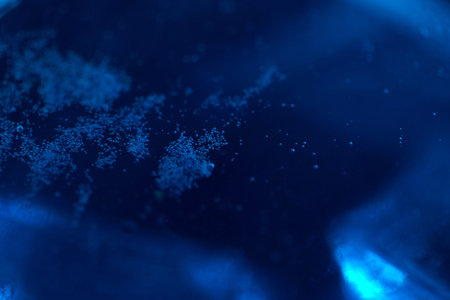Blue sparkling water with ice cubes and bubbles macro close up