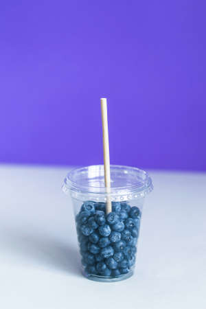Blueberry in the plastic cup smoothie with a paper strawの写真素材