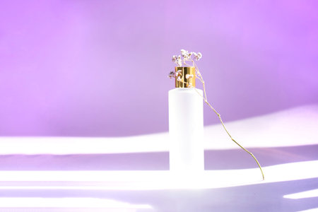 Matte cosmetic bottle with golden cap on the purple background