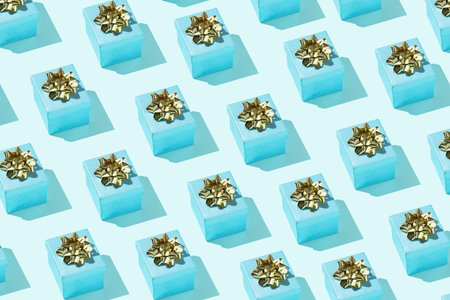 Gift box pattern with golden bow on the pastel blue background festive backdrop minimal trendy...