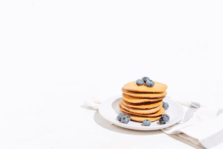American pancakes with blueberries on the white background with cloth