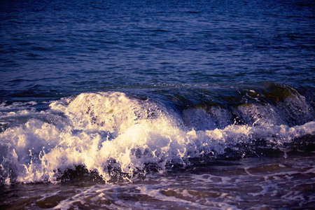 Splashing wave on the sea in the eveningの写真素材