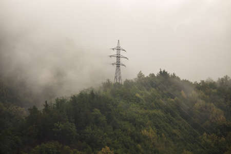 the power line is high in the mountains in the fog.の写真素材