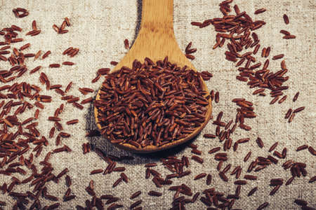 Jasmine Brown rice in a wooden spoon on natural napkin close-up,の写真素材
