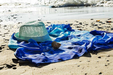 hat and beach tunic on the beach with the sea in the background.の写真素材