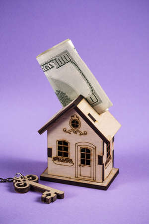 Loan or save for buy a house and real estate concept. Mortgage loading and calculator property document concept. wooden house stands with key and dollars.の写真素材