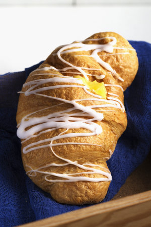 Fresh and tasty croissant with cream selective focus on the blue natural textile .