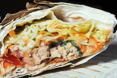 Burrito wraps with chicken and vegetables in pita bread, shawarma, Close up.