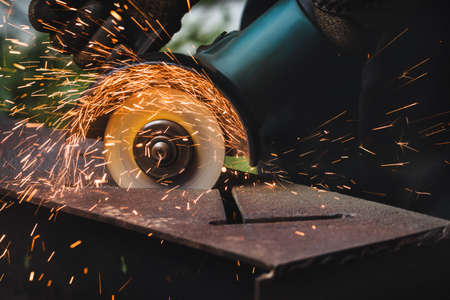 grinding cutting metal sheet with angle grinder machine and sparks, Close up.の写真素材