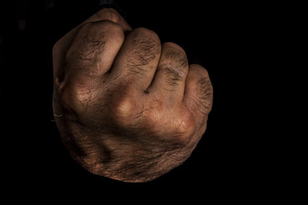Male punch fist aggressiveness masculinity inheritance, the concept of challenge. Isolated on black.