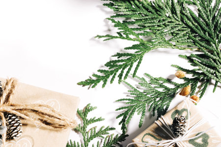 Christmas presents with handmade gift box decorated with pine cones and twigs on white background,...