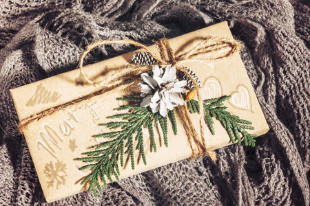 Vintage Christmas presents with gift box decorated with pine cones and twigs on on a cotton fabric...