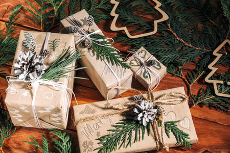 Christmas background with handmade gift boxes, clews of rope and decorations with pine cones and...