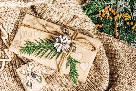Christmas presents with gift box decorated with pine cones and twigs on on a cotton fabric background, preparation for holidays. Christmas presents and New Year. Handmade. Selective focusの写真素材