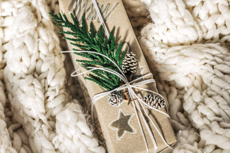 Christmas presents with gift box decorated with pine cones and twigs on on a cotton fabric...