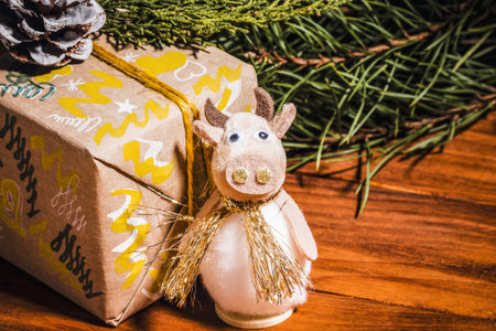 Happy New Year 2021, bull toy symbol of the year on a wooden background with Christmas decor and...