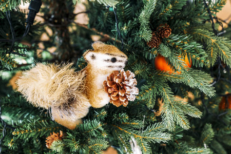 Toy Christmas orange Fluffy Squirrel With Cone Close-Up Sits on the Christmas tree