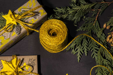 Christmas yellow handmade gift boxes on black background top view. Merry Christmas frame. Winter xmas holiday theme. Happy New Year. Flat lay.の写真素材