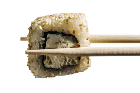 holding fresh sushi roll with wooden chopsticks, isolated on white backgroundの写真素材