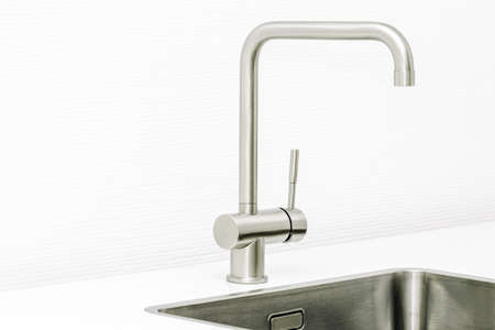 Close up of a worktop of a modern kitchen and the steel sink and water tap.の写真素材