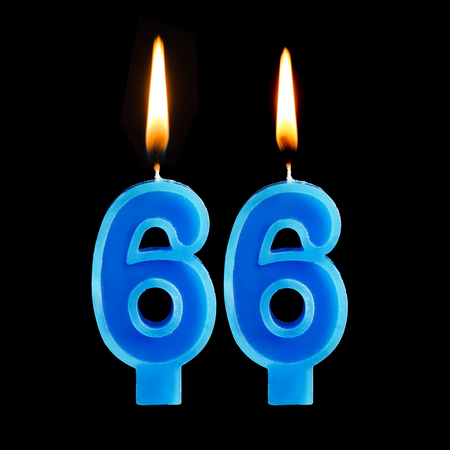 Burning birthday candles in the form of 66 sixty six for cake isolated on black background.の写真素材