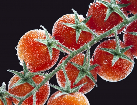 Cherry tomatoes in water with air bubbles on black  backgroundの写真素材