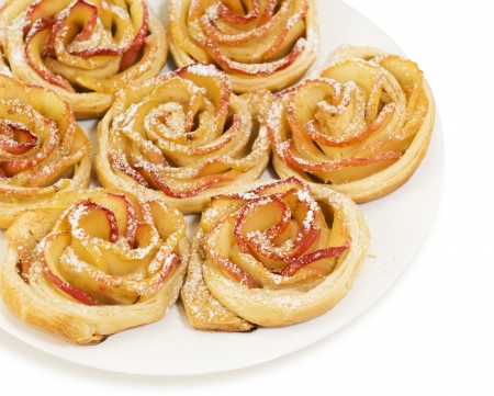 Sweet rolls with apples in the form of roses on plate on white isolated backgroundの写真素材